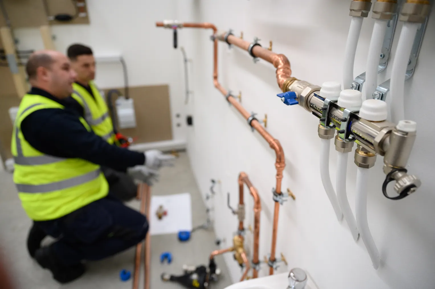 Technicians install heat pump systems at a training facility.